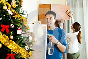 Smiling couple dusting wooden furiture