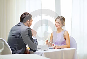 Smiling couple eating dessert at restaurant