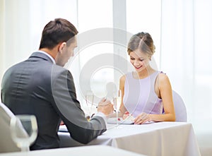 Smiling couple eating dessert at restaurant