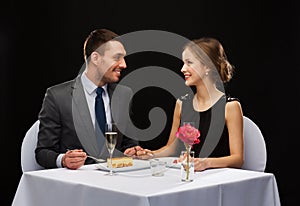 Smiling couple eating dessert at restaurant