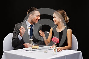 Smiling couple eating dessert at restaurant