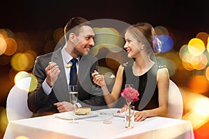 Smiling couple eating dessert at restaurant