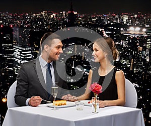 Smiling couple eating dessert at restaurant