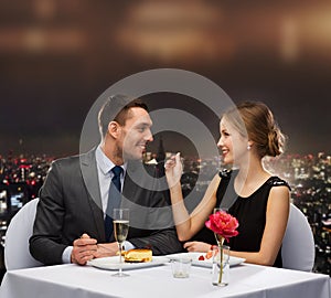 Smiling couple eating dessert at restaurant