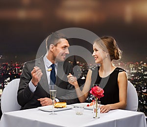 Smiling couple eating dessert at restaurant