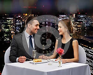 Smiling couple eating dessert at restaurant