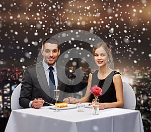 Smiling couple eating dessert at restaurant