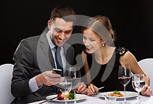 Smiling couple eating main course at restaurant