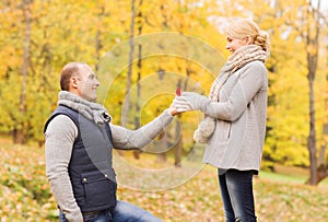 Smiling couple with engagement ring in gift box