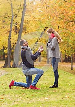 Smiling couple with engagement ring in gift box