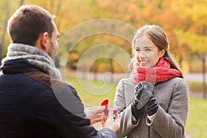 Smiling couple with engagement ring in gift box