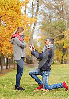 Smiling couple with engagement ring in gift box