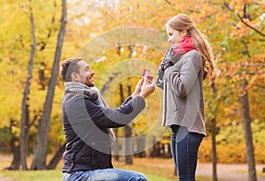 Smiling couple with engagement ring in gift box