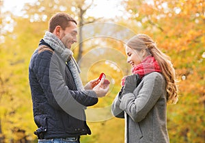 Smiling couple with engagement ring in gift box