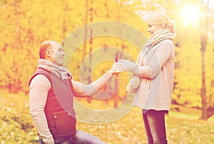 Smiling couple with engagement ring in gift box