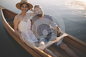 Smiling couple enjoy boating on the lake