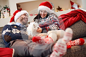 Smiling couple enjoying in the holidays and playing with dog