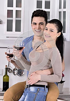Smiling couple enjoying red vine in the kitchev