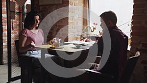 Smiling couple enjoying romantic meeting at cafe talking spending time together in chinese tea cafe. Man closes woman's