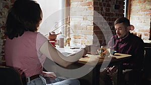 Smiling couple enjoying romantic meeting at cafe talking spending time together in chinese tea cafe. Woman closes man's