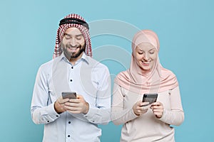 Smiling couple friends arabian muslim man wonam in keffiyeh kafiya ring igal agal hijab clothes isolated on blue