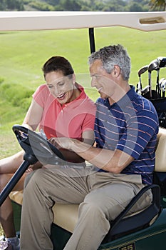 Smiling couple in golf cart