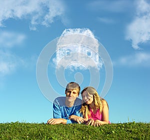 Smiling couple on grass and dream cloud house photo