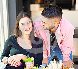 Smiling couple of a happy man an a woman having a drink in a cafÃ¨ bar.concept about the joy and fun to spend time together drinki