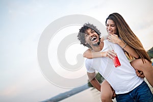 Smiling couple having fun over sky background. Holidays, vacation, love and friendship concept