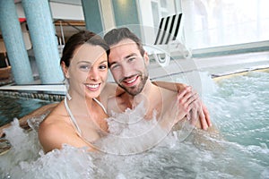 Smiling couple having a good time in jacuzzi