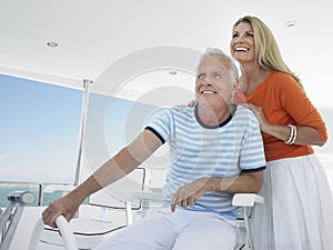 Smiling Couple At Helm Of Yacht