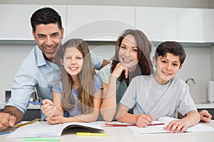 Smiling couple helping kids with homework at home