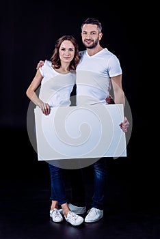 Smiling couple holding blank card