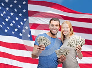 Smiling couple holding dollar cash money