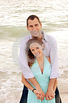 Smiling couple holding each other looking at viewe