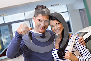 Smiling couple holding their new car key