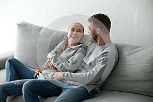 Smiling couple hugging relaxing at cozy sofa