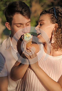 Smiling couple with ice cream walking outdoors