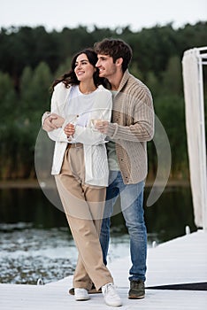 Smiling couple in knitted cardigans holding