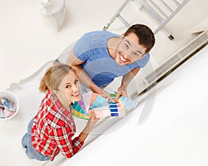 Smiling couple looking at color samples at home