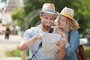 smiling couple looking at map while on holiday