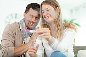 smiling couple looking at pregnancy test