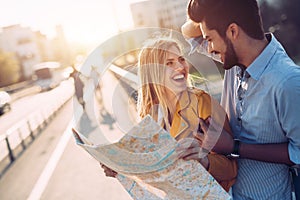 Smiling couple in love traveling with a map outdoors