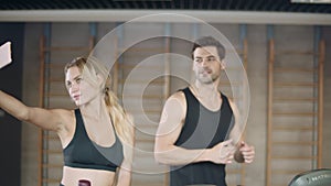 Smiling couple making selfie in sport club after training.