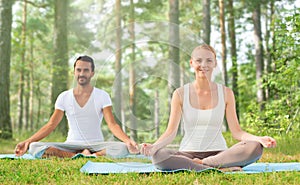 Smiling couple making yoga exercises outdoors