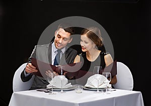 Smiling couple with menus at restaurant photo