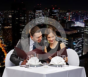 Smiling couple with menus at restaurant photo