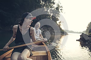 Smiling couple paddling canoe on a lake