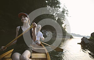 Smiling couple paddling canoe on a lake