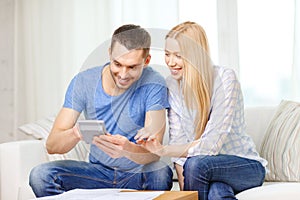 Smiling couple with papers and calculator at home
